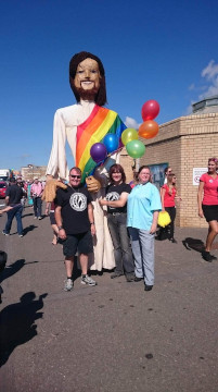 Safe Harbour members marching at Pride with a 12-foot-tall Jesus with a rainbow flag sash.